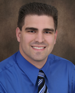 Headshot of Curtis Gerke, brown haired Caucasian male wearing a blue dress shirt and tie.